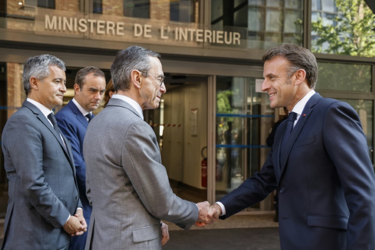 Le président de la République Emmanuel Macron (à droite) et le ministre de l'Intérieur Bruno Retailleau se serrent la main, le 14 mai 2025 à Nanterre, près de Paris