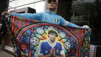 Un fan tient un drapeau à l'effigie de la légende du football argentin Diego Maradona devant le tribunal à San Isidro, le 8 octobre 2026 en Argentine