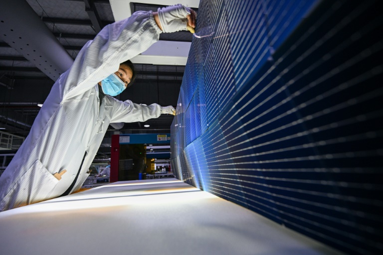 Un ouvrier travaille sur des modules photovoltaïques (PV) pour panneaux solaires dans une usine de Suqian, dans la province du Jiangsu, à l'est de la Chine, le 23 janvier 2025