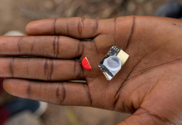 Un toxicomane tient la moitié d'un comprimé rouge à base de tapentadol à Abuja, le 24 février 2026 au Nigeria