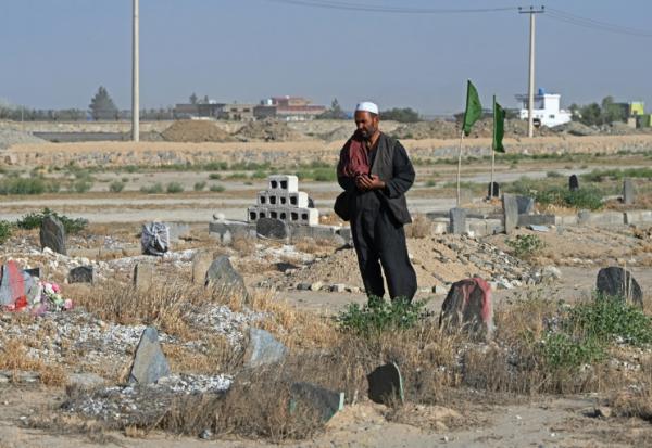 Photo prise le 1er juin 2025 près de kaboul de Gul Ajan Hotak priant sur la tombe de son défunt fils Shafiullah Hotak, mort après être tombé d'un avion C-17 de l'armée de l'air américaine pour fuir le pays dirigé par les talibans 