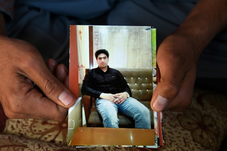 Photo prise le 7 décembre 2021 de Payanda Mohammed Ibrahimi montrant une image de son fils Fida Mohammad Amir, un dentiste afghan décédé après être tombé d'un avion de l'armée de l'air américaine alors qu'il cherchait à quitter la capitale tombée aux mains des talibans 