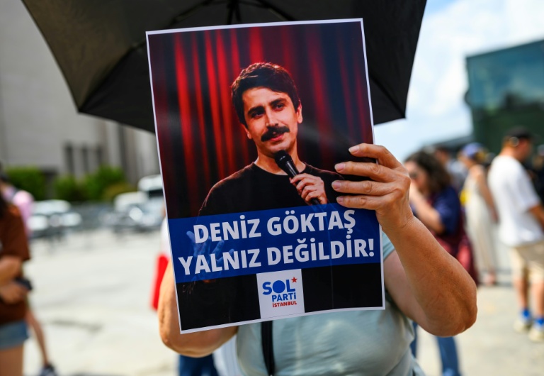 Une personne tient une pancarte de soutien à l'humoriste turc Deniz Goktas, sur laquelle on peut lire 