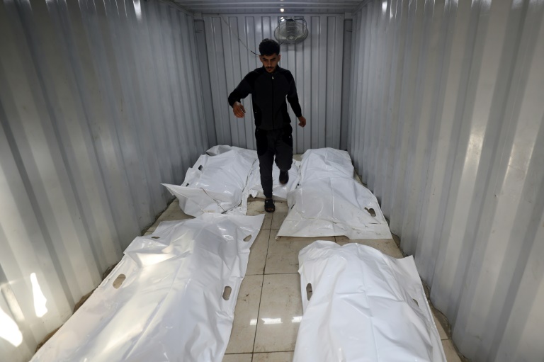Des corps de victimes dans des sacs blancs à même le sol dans un hôpital du camp de réfugiés de Nouseirat, dans le centre de la bande de Gaza, le 27 septembre 2025
