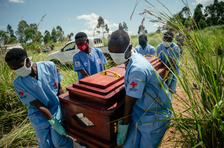 Des membres d'une équipe de la Croix-Rouge congolaise transportent le cercueil d'une femme qui serait décédée des suites de la maladie à virus Ebola lors de son enterrement dans les règles de sécurité dans un cimetière de Bunia, en RDC, le 7 juin 2026.