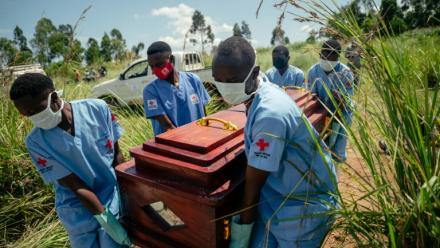 Des membres d'une équipe de la Croix-Rouge congolaise transportent le cercueil d'une femme qui serait décédée des suites de la maladie à virus Ebola lors de son enterrement dans les règles de sécurité dans un cimetière de Bunia, en RDC, le 7 juin 2026.