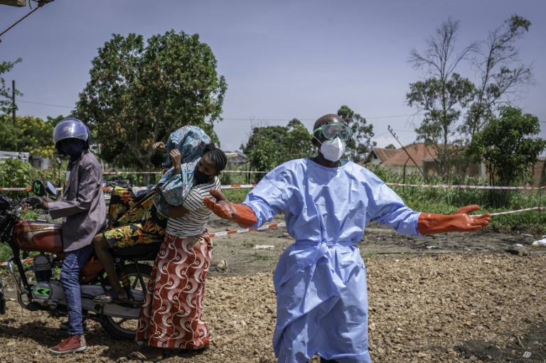 Dieudonné Sezabo, un agent de santé, demande de l'aide pour accueillir une jeune femme soupçonnée d'avoir la maladie Ebola, à l'hôpital de Rwampara, dans le nord-est de la République démocratique du Congo (RDC) le 26 mai 2026

