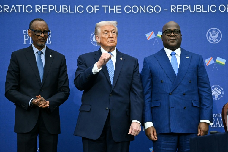 Le président américain Donald Trump entouré par les chefs d'Etat rwandais Paul Kagame (G) et congolais Etienne Tshisekedi (D) lors de la cérémonie de signature d'un accord de paix, à Washington le 4 décembre 2025

