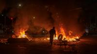 Un homme jette un pneu dans un feu lors d'affrontements avec la police, alors que des manifestants protestent contre les résultats préliminaires du second tour de l'élection présidentielle à Bogotá, en Colombie, le 21 juin 2026