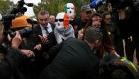 Les membres du groupe Kneecap, dont le chanteur Liam O'Hanna, alias Mo Chara, portent des cagoules aux couleurs du drapeau irlandais à leur arrivée au tribunal de Woolwich, à Londres, le 26 septembre 2025