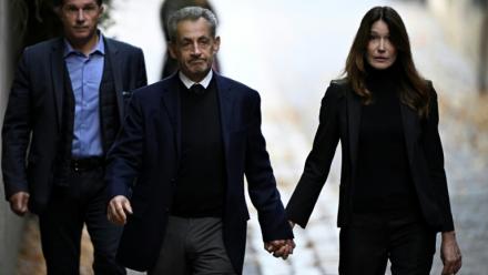 Nicolas Sarkozy (C) et son épouse Carla Bruni-Sarkozy, le jour de son incarcération à la prison de la Santé, le 21 octobre 2025 à Paris