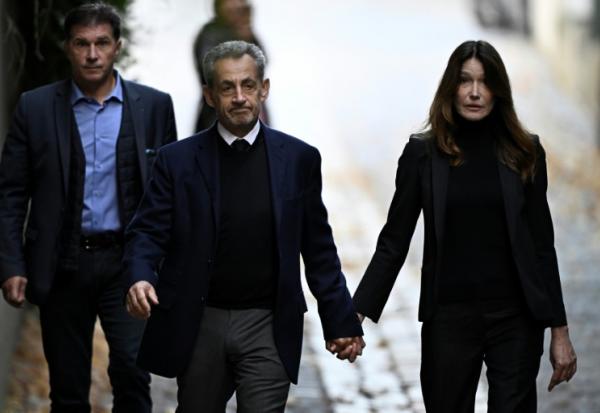 Nicolas Sarkozy (C) et son épouse Carla Bruni-Sarkozy, le jour de son incarcération à la prison de la Santé, le 21 octobre 2025 à Paris