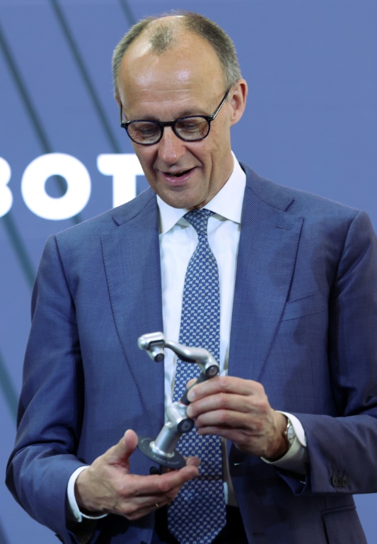 le chancelier allemand Friedrich Merz sur le stand d'Agile Robots à la foire industrielle d'Hanovre, 20 avril 2026 dans le nord de l'Allemagne