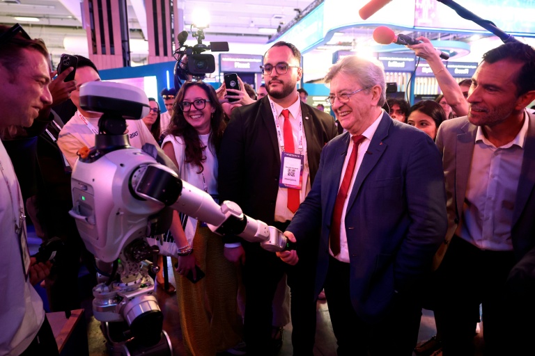 Le leader de La France insoumise (LFI), Jean-Luc Mélenchon, serre la main d'un robot humanoïde lors de sa visite au salon VivaTech, le 19 juin 2026 à Paris