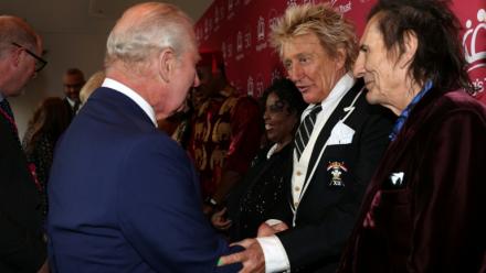 Le chanteur britannique Rod Stewart (c) salue le roi Charles III (g), aux côtés du guitariste britannique Ronnie Wood, à Londres, le 11 mai 2026