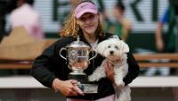 La Russe Mirra Andreeva pose avec son trophée de Roland-Garros et son chien, le 6 juin 2026