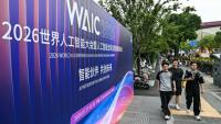 Des passants longent une affiche de la Conférence mondiale sur l'intelligence artificielle (WAIC), le 16 juillet 2026 à Shanghai en Chine