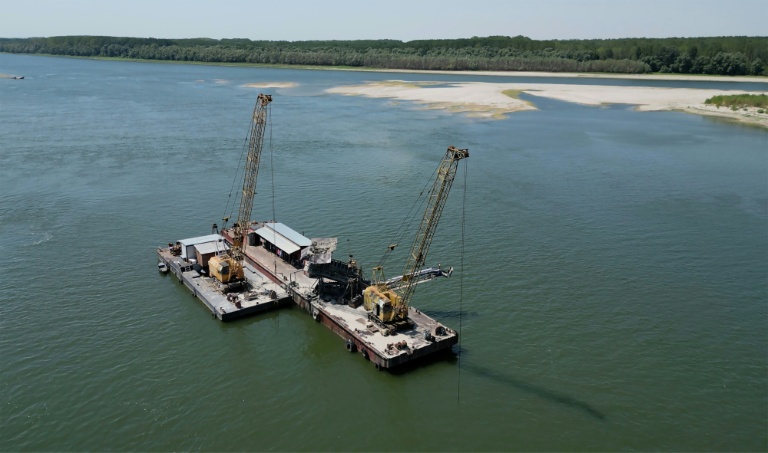 Deux dragueuses travaillent à approfondir le chenal navigable du Danube près du village de Cochirleni en Roumanie, le 12 août 2026