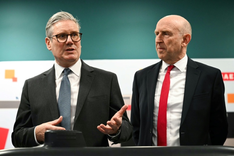 Le Premier ministre britannique Keir Starmer (à gauche) et le secrétaire à la Défense John Healey lors d'une rencontre avec des apprentis de l'entreprise aérospatiale BAE system, à Barrow-in-Furness, dans le nord-ouest de l'Angleterre, le 20 mars 2025