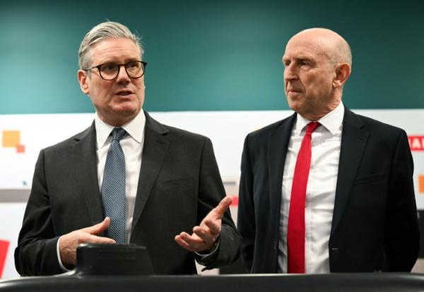 Le Premier ministre britannique Keir Starmer (à gauche) et le secrétaire à la Défense John Healey lors d'une rencontre avec des apprentis de l'entreprise aérospatiale BAE system, à Barrow-in-Furness, dans le nord-ouest de l'Angleterre, le 20 mars 2025