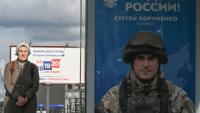 Une passante près d'une affiche faisant la promotion de l'armée russe en Ukraine sur laquelle on peut lire "Fierté de la Russie", à Moscou le 15 septembre 2026