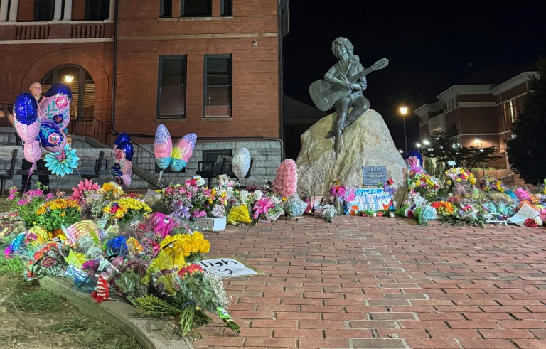 Au pied de la statue de Dolly Parton, des fleurs déposées en hommage le 25 août 2026 à Sevierville (Etats-Unis)