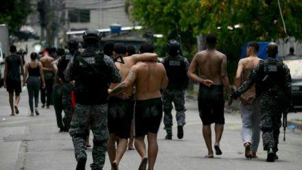 Des policiers escortent des criminels présumés arrêtés lors d'une opération dans la favela de Vila Cruzeiro, dans le complexe de Penha, à Rio de Janeiro, le 28 octobre 2025 au Brésil
