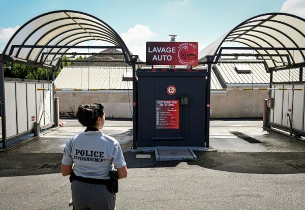 La police de l'environnement inspecte une station de lavage automobile à Saint-Quentin-en-Yvelines, près de Paris, le 5 août 2022