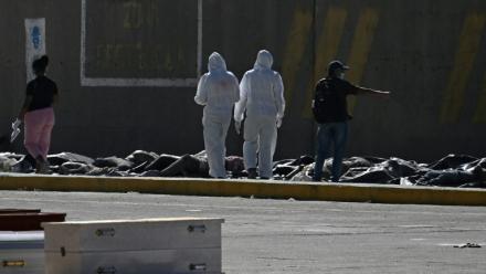 Des experts médicolégaux procèdent à l'identification de corps étendus au sol dans une morgue de fortune située dans le port de La Guaira, au Venezuela, le 29 juin 2026