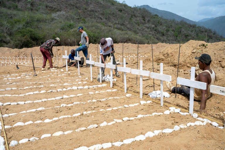 Des personnes mettent en ordre des tombes de victimes non-identifiées du double séisme au Venezuela, le 5 juillet 2026 à Catia La Mar, dans l'Etat de La Guaira