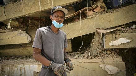 Raul Alvarado (g) cherche des proches disparus sous les décombres de l'immeuble OPP 26 de 16 étages ç Carabellada, dans l'Etat de La Guaira, le 6 juillet 2026 au Venezuela