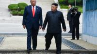 Le président américain Donald Trump (g.) et le dirigeant nord-coréen Kim Jong Un traversent ensemble la ligne de démarcation militaire qui sépare la Corée du Nord et la Corée du Sud, le 30 juin 2019 à Panmunjom en Corée du Sud