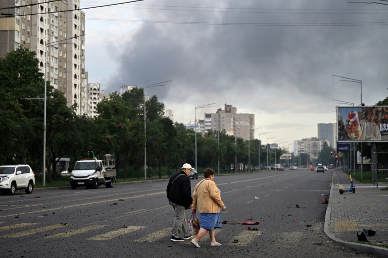 Des habitants marchent dans une rue de la capitale de l'Ukraine, Kiev, après une attaque de missiles russes, le 11 juillet 2026
