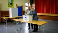 Un couple de personnes âgées vote aux élections législatives, le 22 mars 2026 à Arnace en Slovénie 