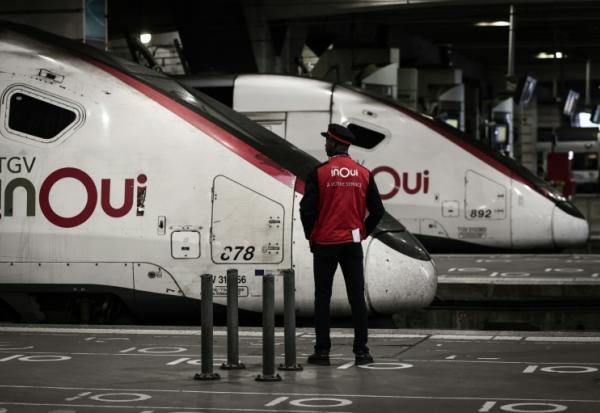 Un employé de la SNCF se tient près d'un TGV Inoui à la gare Montparnasse, le 8 mai 2025 à Paris