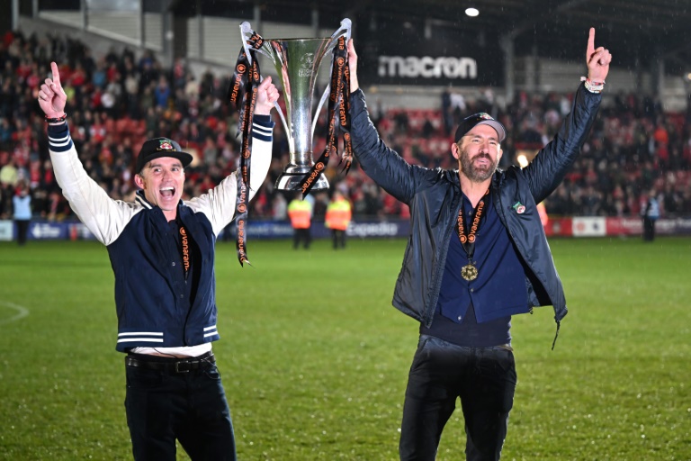 Les acteurs Rob McElhenney (g) et Ryan Reynolds, propiétaires du cludb de Wrexham, avec le trophée de National League (5e div.), le 22 avril 2022