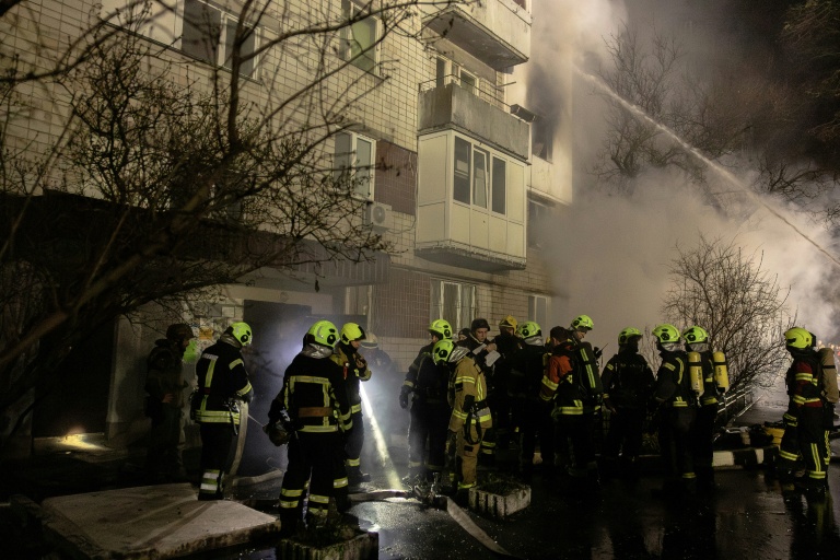 Des pompiers devant un immeuble résidentiel touché par une attaque de drone russe à Vyshhorod, dans la région de Kiev, le 30 novembre 2025 en Ukraine