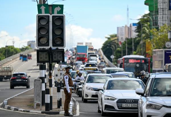 Des automobilistes passent à côté de feux de signalisation éteints, après une panne d’électricité nationale, le 17 octobre 2026 à Colombo, au Sri Lanka