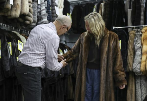 Le propriétaire du magasin de fourrures Madison Avenue Furs à New York, Larry Cowit, avec une cliente, le 10 mars 2026