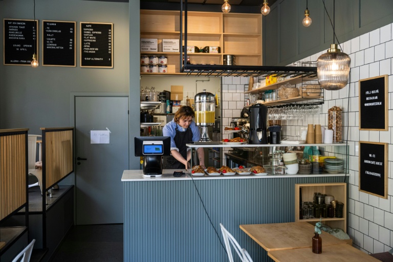 Kajetan Grzelczak derrière son comptoir  au café Andon à Stockholm, entièrement dirigé par l'IA, le 27 avril 2026