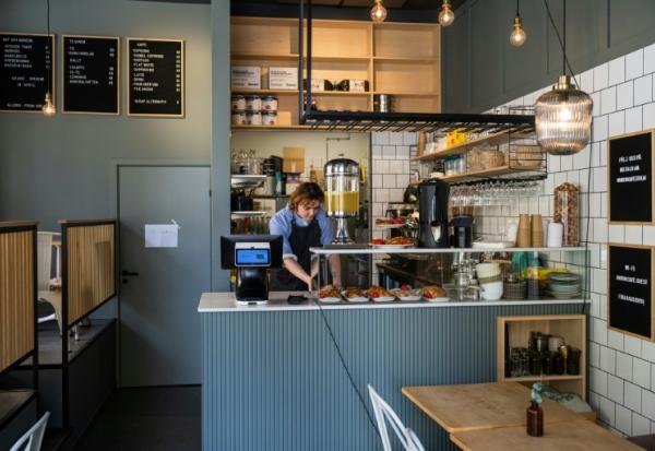 Kajetan Grzelczak derrière son comptoir  au café Andon à Stockholm, entièrement dirigé par l'IA, le 27 avril 2026