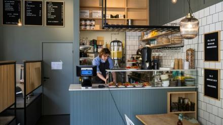 Kajetan Grzelczak derrière son comptoir  au café Andon à Stockholm, entièrement dirigé par l'IA, le 27 avril 2026