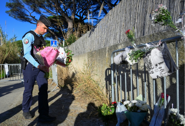 Un gendarme dépose des fleurs devant une barrière en hommage à Brigitte Bardot à l'entrée de sa propriété de Saint-Tropez, le 28 décembre 2025