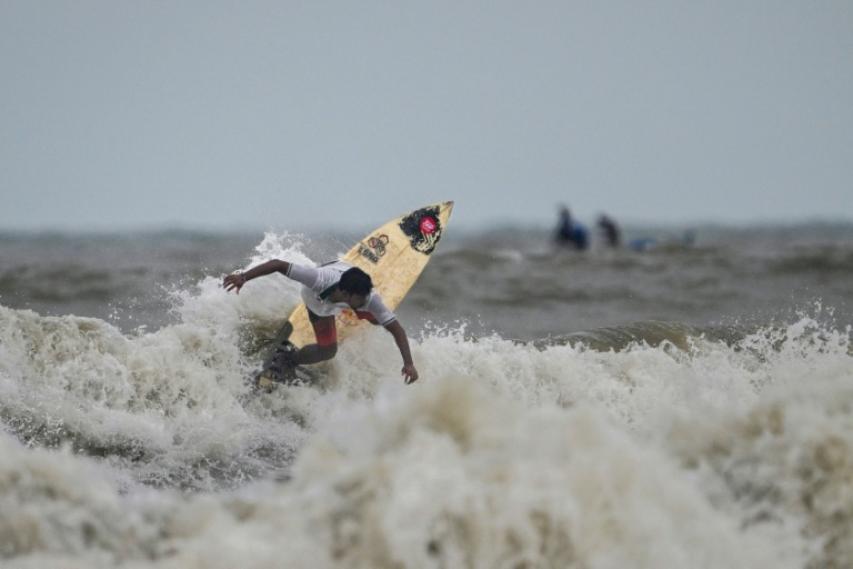 Le surfeur Mohammad Mannan prend des vagues le long d'une plage à Cox's Bazar, dans le sud-est du Bangladesh, le 22 juin 2026  