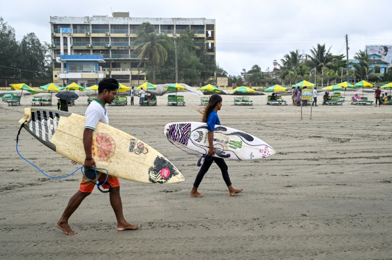 Les surfeurs Mohammad Mannan et Fatima Akhter sur la plage de Cox's Bazar, dans le sud-est du Bangladesh, le 22 juin 2026  