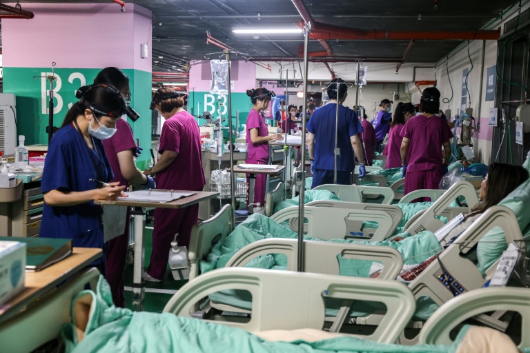 Du personnel médical soigne des patients blessés (simulés) dans une installation médicale souterraine lors d'un exercice de défe,se à New Taipei, le 13 août 2026 sur ll'île de Taïwan