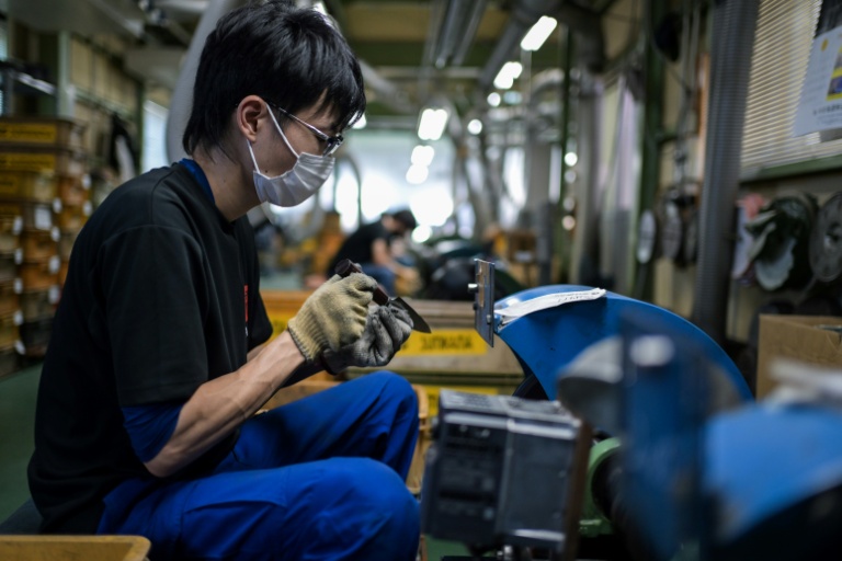 Un employé du fabricant japonais de couteaux Sumikama affûte des lames dans son usine de Seki,au Japon, le 22 juillet 2025