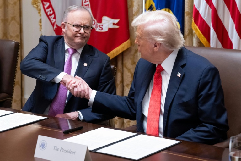 Le président américain Donald Trump (d) et le Premier ministre australien Anthony Albanese se serrent la main après la signature d'un accord sur les minéraux critiques à la Maison Blanche, le 20 octobre 2025 à Washington