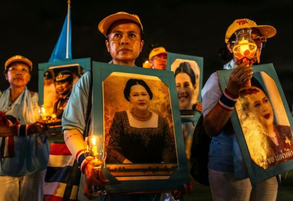 Des partisans de la famille royale tiennent des portraits de la reine mère Sirikit, décédée vendredi, ici le 12 août 2025 à Bangkok