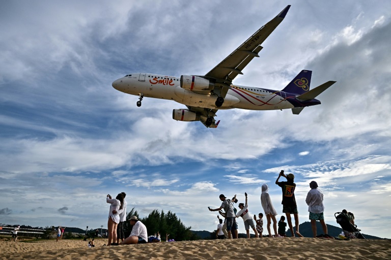 Des touristes sur la plage de Mai Khao, sur l'île de Phuket, près de l'aéroport international, le 18 novembre 2023 en Thaïlande